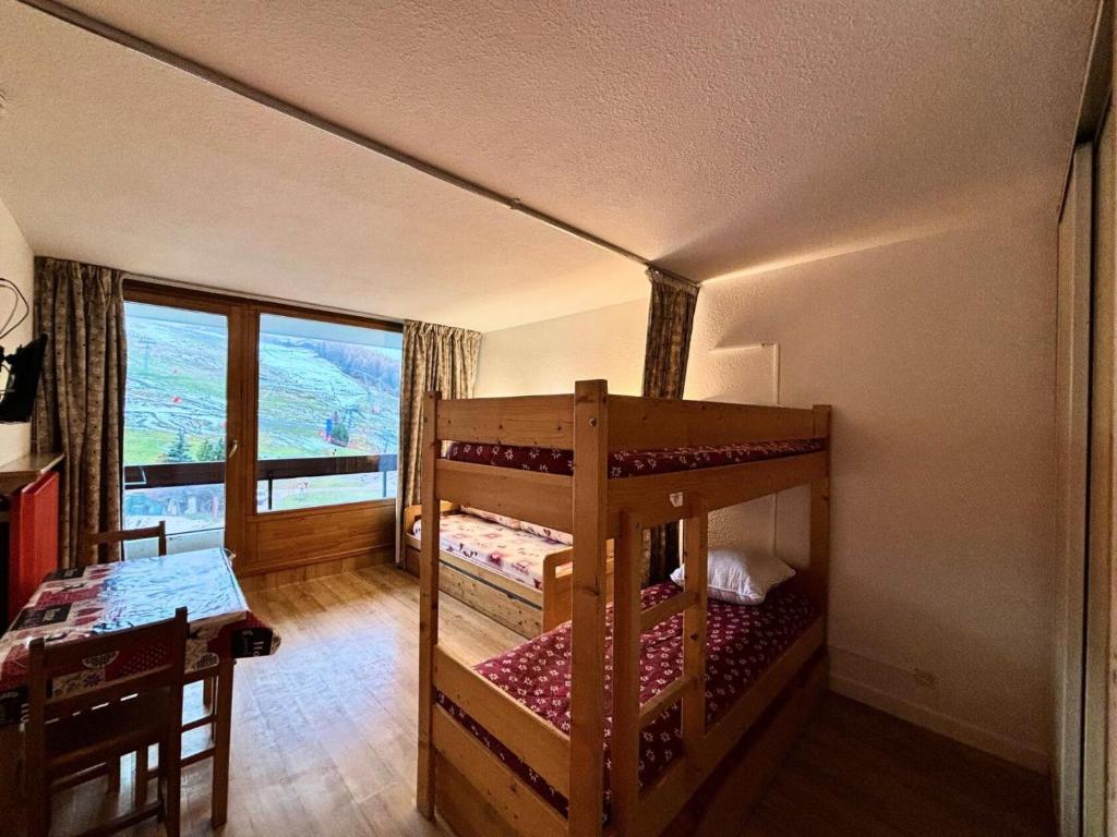 - une chambre avec 2 lits superposés, une table et une fenêtre dans l'établissement Résidence Lac Du Lou - Studio 4 pers ski aux pieds au coeur des Menuires MAE-5054, aux Menuires