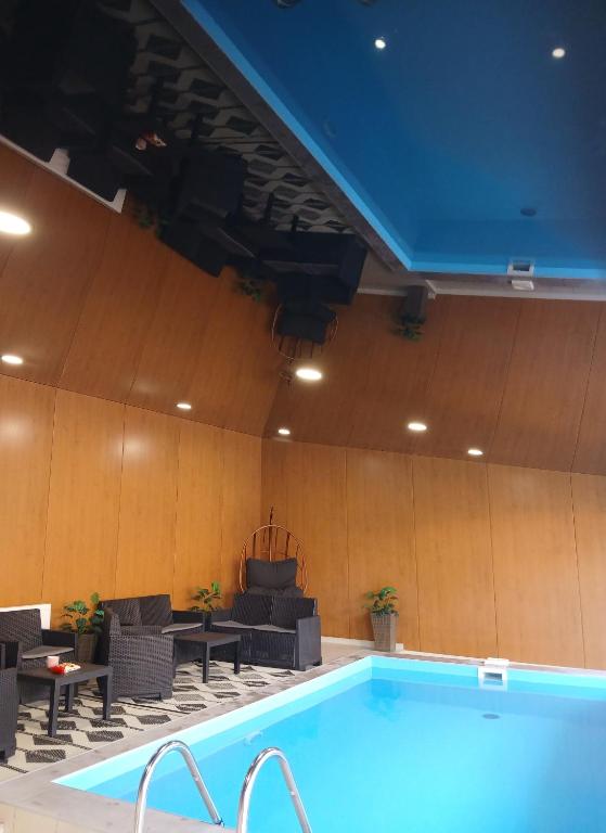 a swimming pool with chairs and a table next to it at Къща Принцеса Анастасия in Chiprovtsi