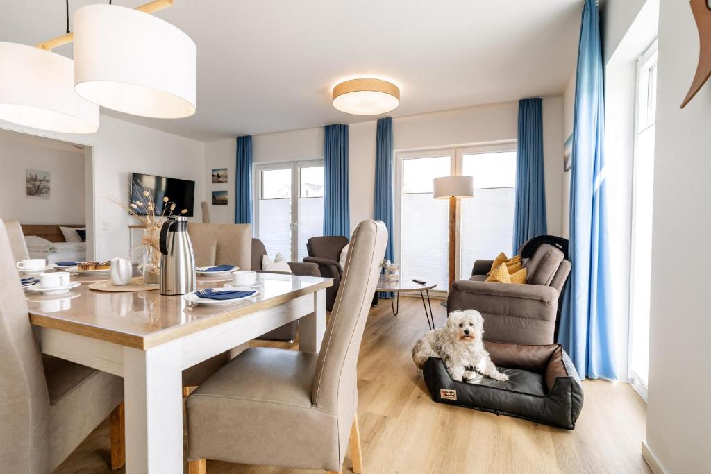 a dining room with a table and a dog sitting on a chair at Nordsee Oase 50 0 N in Wangerland