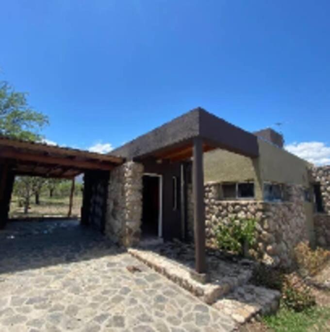 a stone house with a roof and a patio at Casa Despertares - Las Rabonas in Mina Clavero