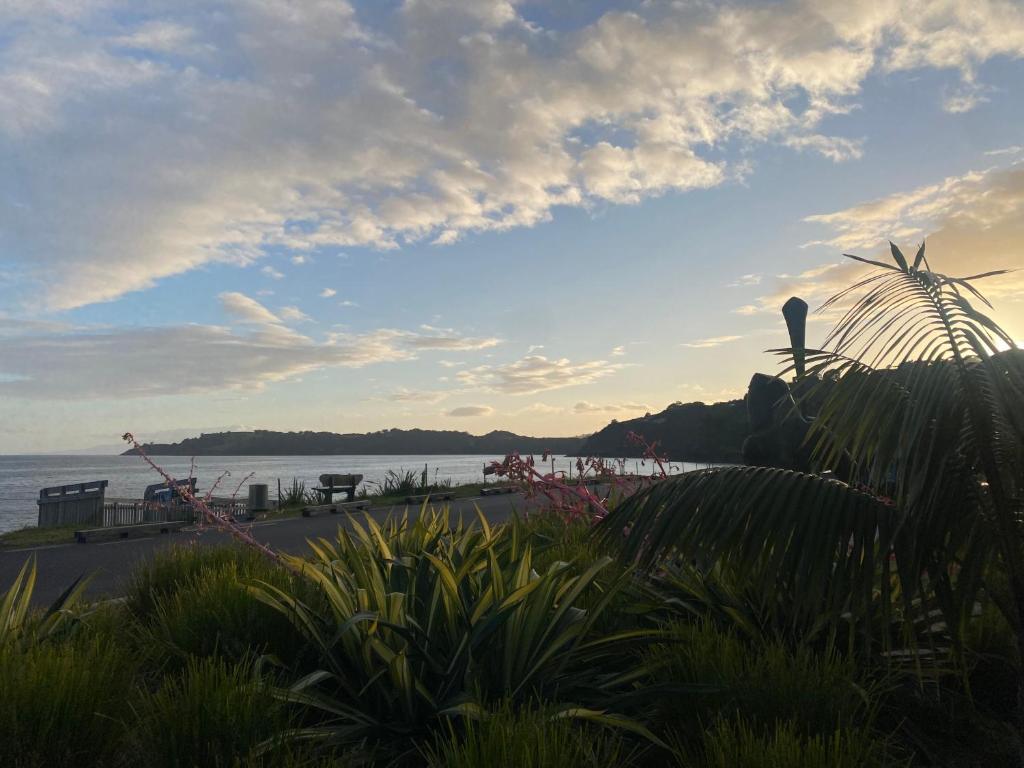 a view of a beach with the ocean in the background at Beachfront on Waiheke in Onetangi