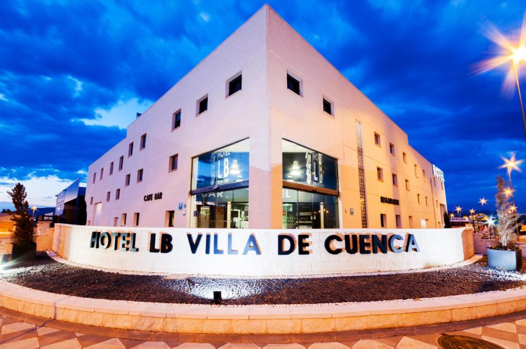 un edificio con una señal delante de él en Hotel LB Villa De Cuenca, en Cuenca