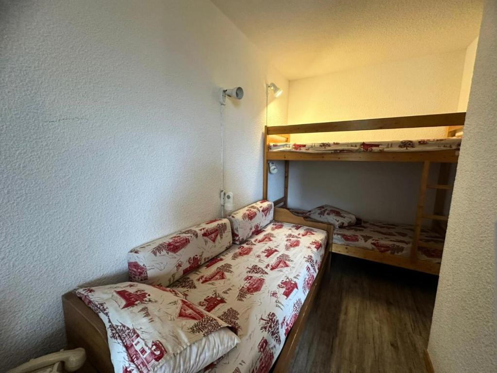 Cette petite chambre comprend un canapé et des lits superposés. dans l'établissement Residence 3000 Bail - Studio pour 4 Personnes 12, à Mâcot La Plagne