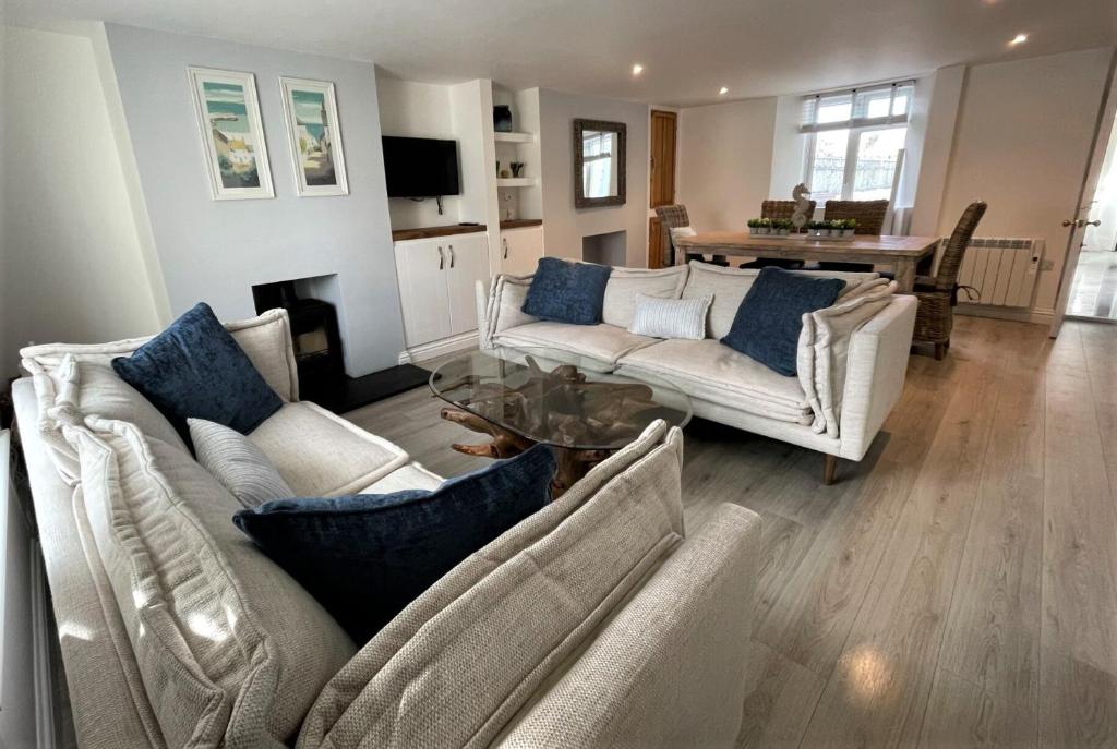 a living room with two couches and a table at The Little Seahorse - Newly Renovated Cottage 5mins Walk The Beach with Hot Tub in Tywardreath