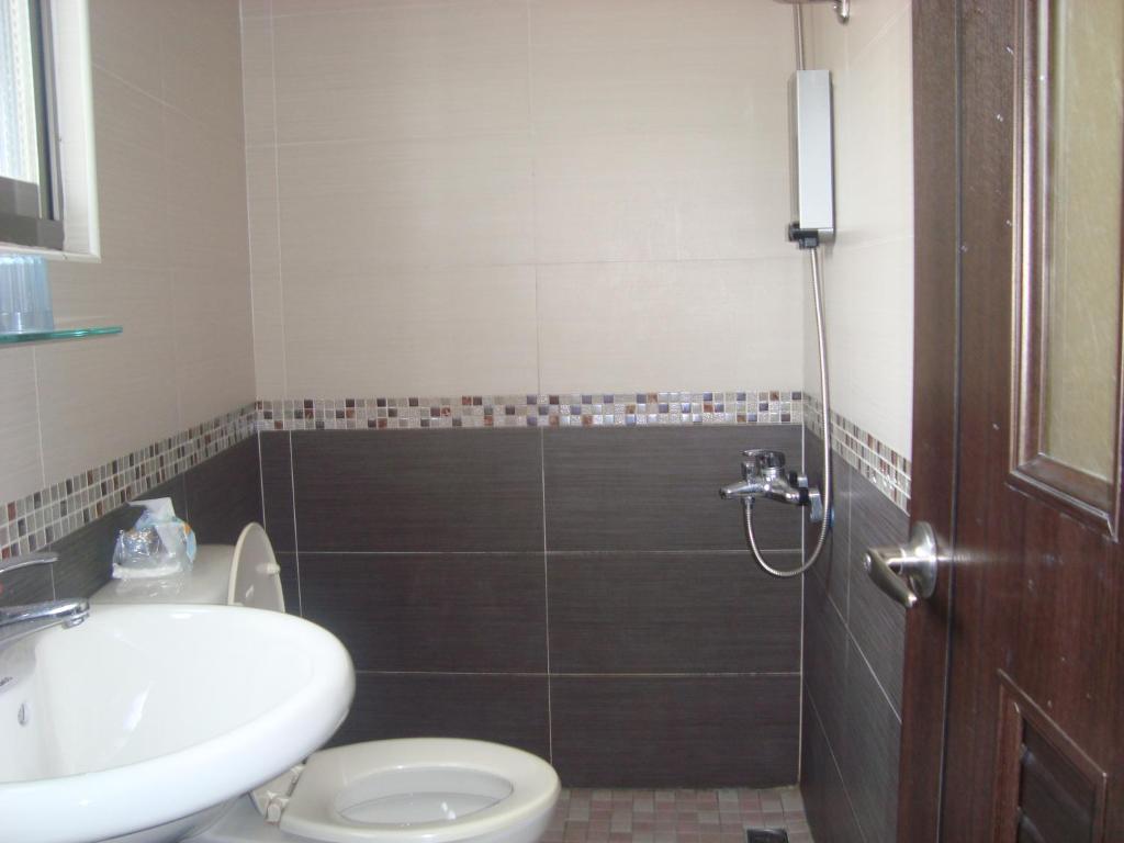 a bathroom with a shower and a toilet and a sink at Fu Yuan B&amp;B in Magong