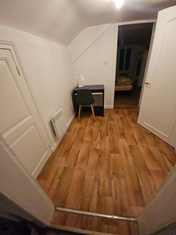 Cette chambre vide est dotée de parquet et d'une porte. dans l'établissement appartement fontaine Saint-Martin, à Tulle