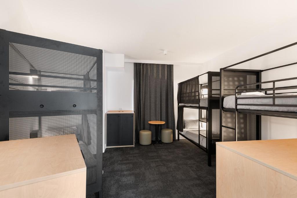 a dorm room with two bunk beds and a kitchen at YHA Sydney Harbour in Sydney