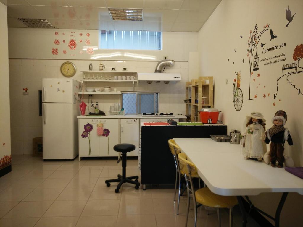 a kitchen with a refrigerator and a table with chairs at Jia Mei Fa Homestay in Taitung City