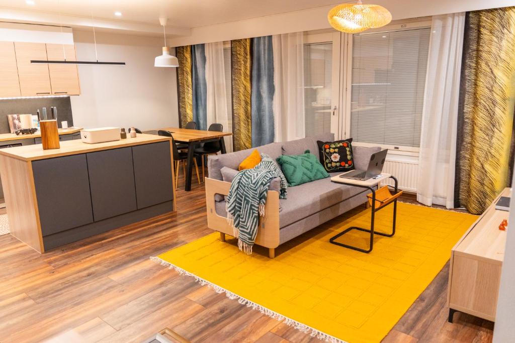 a living room with a couch and a kitchen at City Luppo - Spacious, Smart, Warm, Sauna, Wi-Fi in Rovaniemi