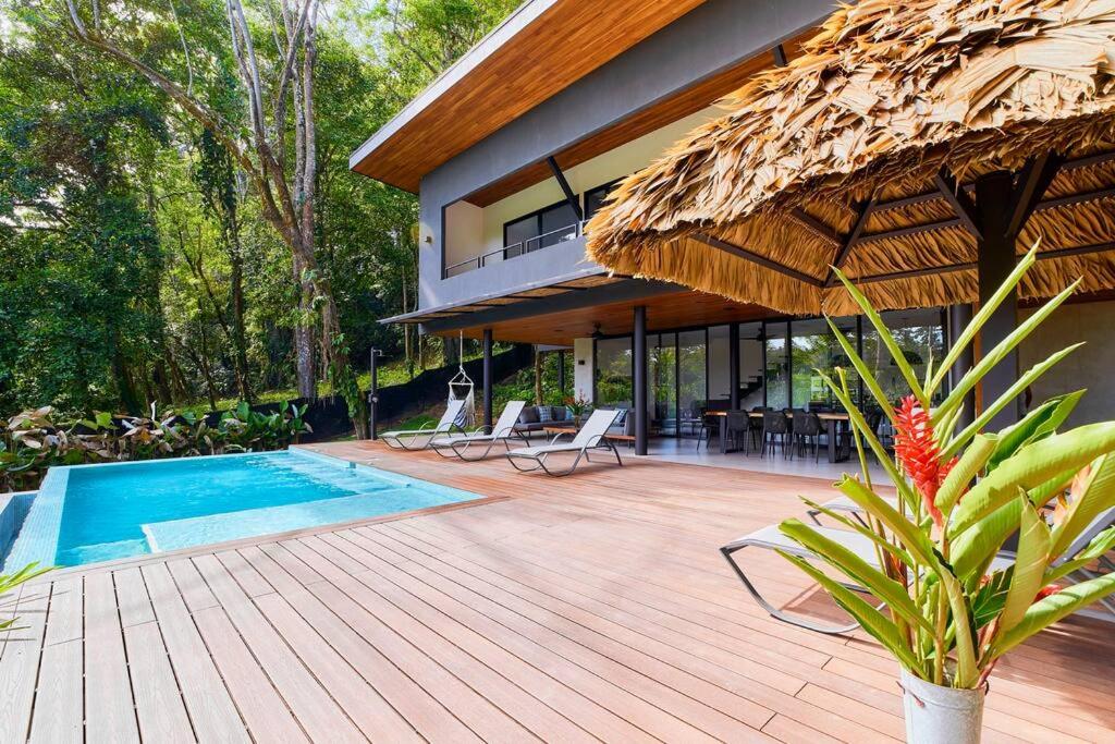 a house with a wooden deck with a swimming pool at Casa Diwo in Puerto Viejo