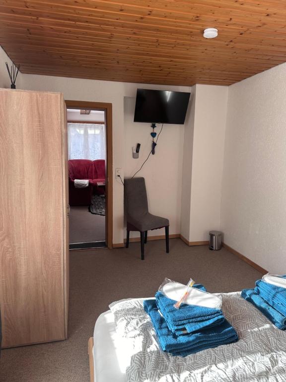 a bedroom with a bed and a chair and a mirror at Familie Zimmer in Ramsen