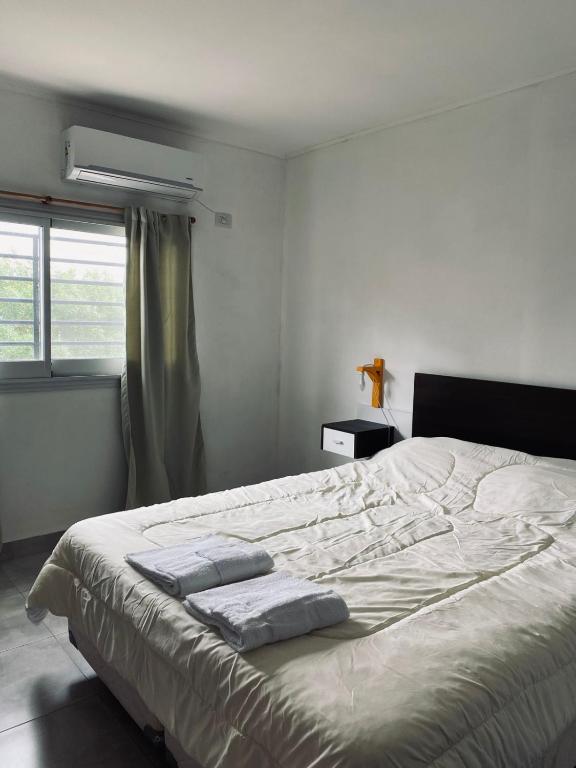 a bedroom with a large bed with towels on it at Departamento 2 - Villa Z in Villa Zorraquín