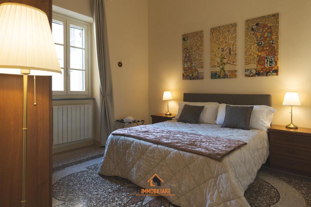 Un dormitorio con una cama y dos lámparas y una ventana. en Intero appartamento 3 letti con garage gratuito, en Livorno