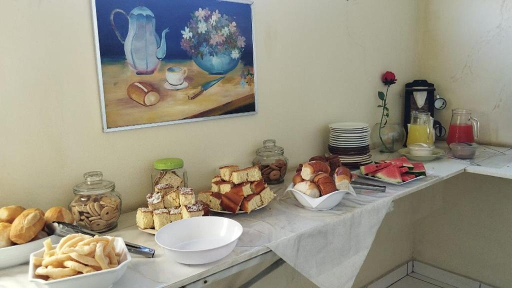 una mesa con varios tipos de pan y repostería. en Hotel Thalita, en Formiga
