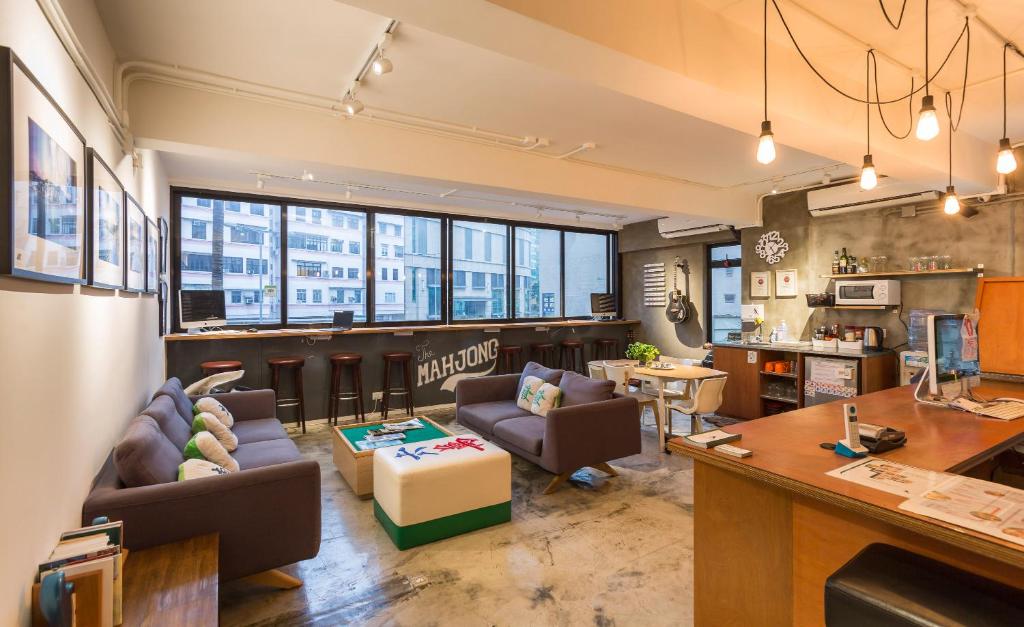 uma sala de estar com sofás e um bar em The Mahjong em Hong Kong