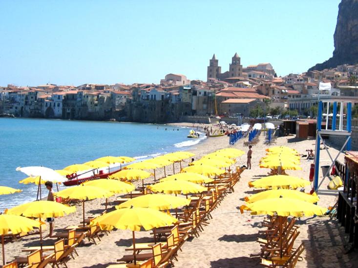 kilka żółtych parasoli na plaży w obiekcie Casa Alba w Cefalù