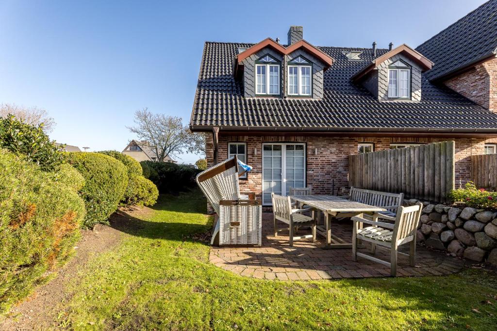 a patio with chairs and a table in front of a house at Sonnenfreude in Westerland