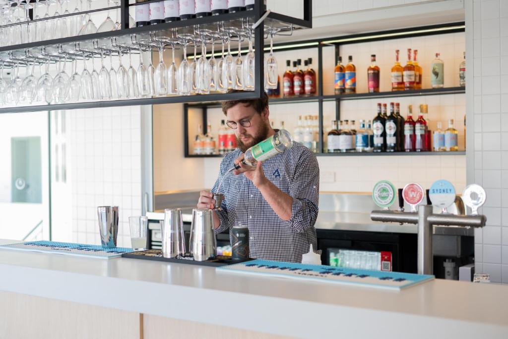 a man standing behind a counter at a bar at YHA Sydney Harbour in Sydney