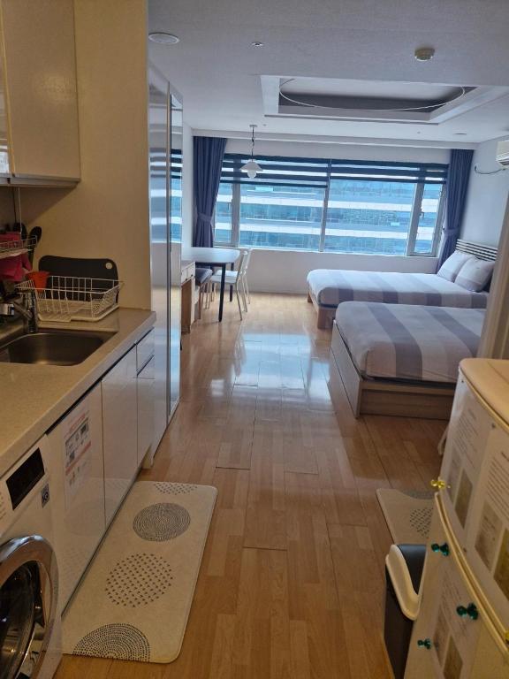 una cucina e un soggiorno con letto e lavandino di Hongdae Residence 3 - 1min from Hongik Uni station Exit #1 a Seul