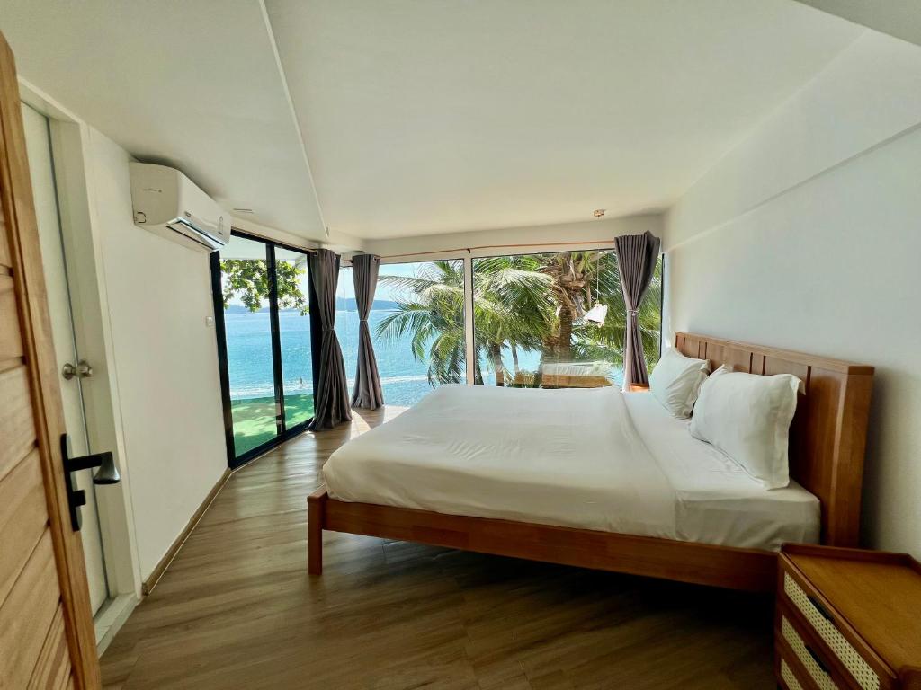 a bedroom with a bed with a view of the ocean at patong sunset villa Phuket in Patong Beach