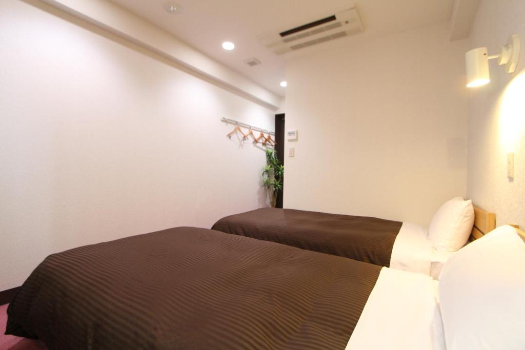 Postel nebo postele na pokoji v ubytování HOTEL LiVEMAX Kitafuchu