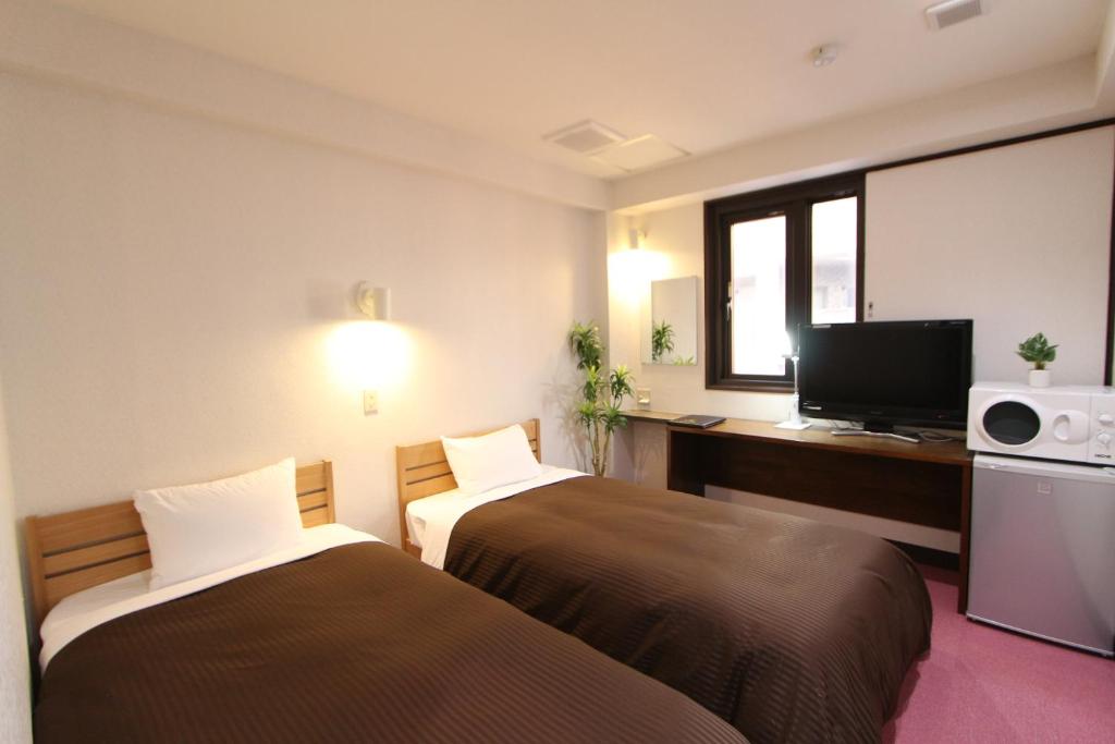 Postel nebo postele na pokoji v ubytování HOTEL LiVEMAX Kitafuchu