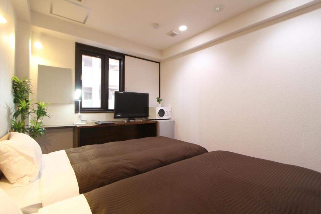 Postel nebo postele na pokoji v ubytování HOTEL LiVEMAX Kitafuchu