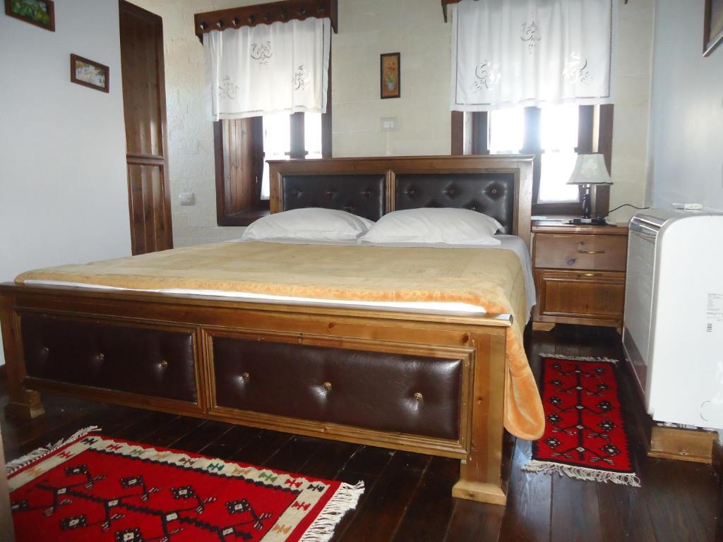a large bed with a wooden frame in a bedroom at Hotel Klea in Berat