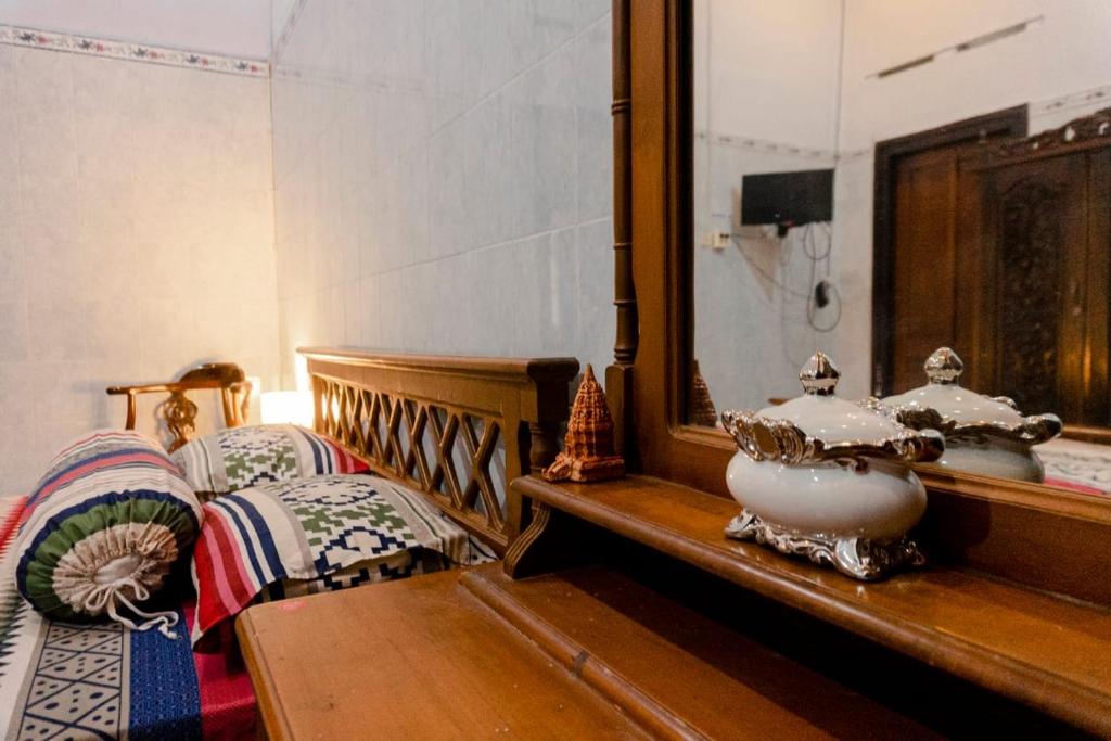 una camera con due letti, uno specchio e un tavolo di Noah House a Yogyakarta