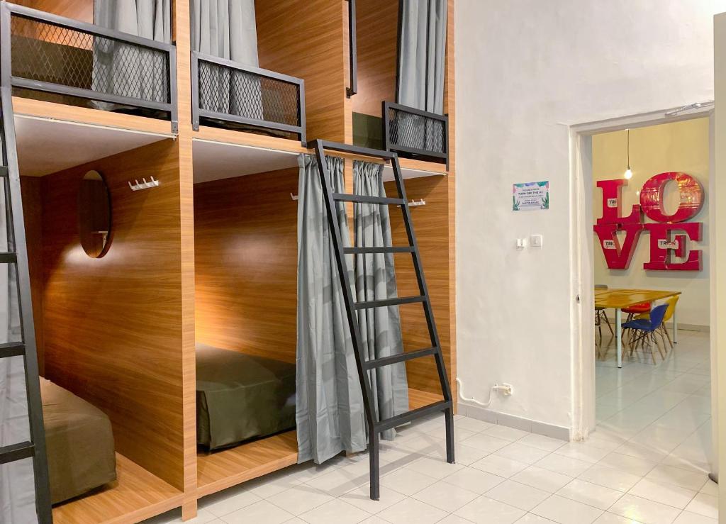 a bunk bed in a room with a ladder at Snooze Malang in Malang