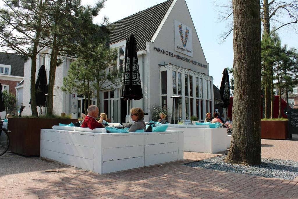 un groupe de personnes assises dans une piscine devant un bâtiment dans l'établissement Parkhotel Auberge Vincent, à Nuenen