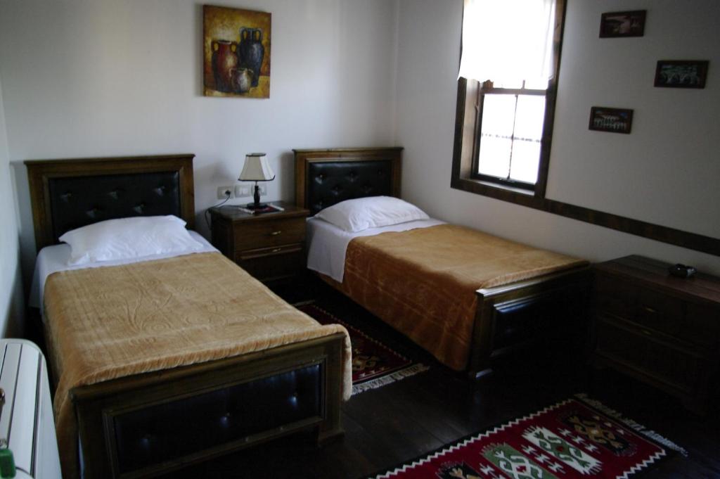a bedroom with two beds and a window at Hotel Klea in Berat