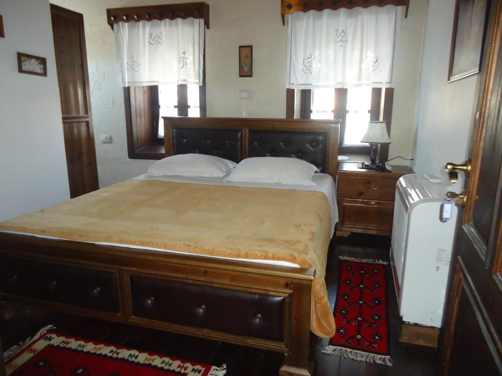 a bedroom with a large wooden bed with white pillows at Hotel Klea in Berat