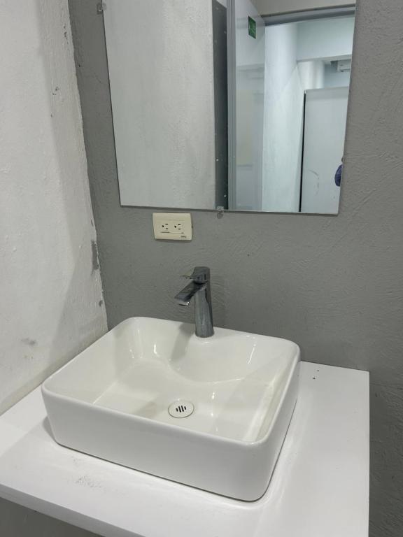 a white sink in a bathroom with a mirror at Hotel Hannabi in Boca Chica