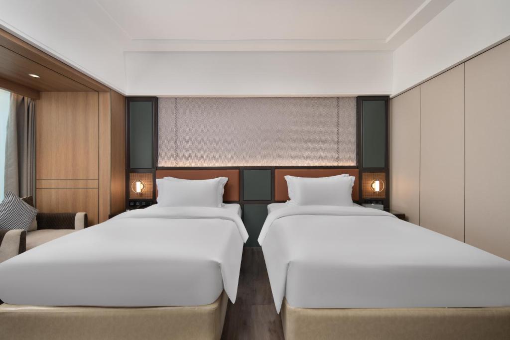 Postel nebo postele na pokoji v ubytování Mehood Lestie Hotel Dongguan Chang'an
