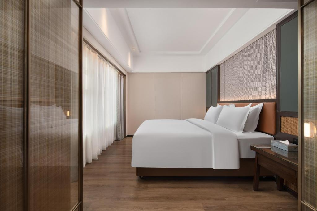 Postel nebo postele na pokoji v ubytování Mehood Lestie Hotel Dongguan Chang'an