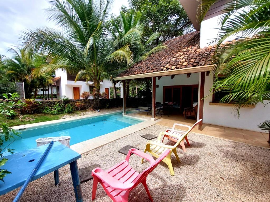 a house with a pool with chairs and a table at Beach house between Tamarindo and Avellanas in Santa Cruz
