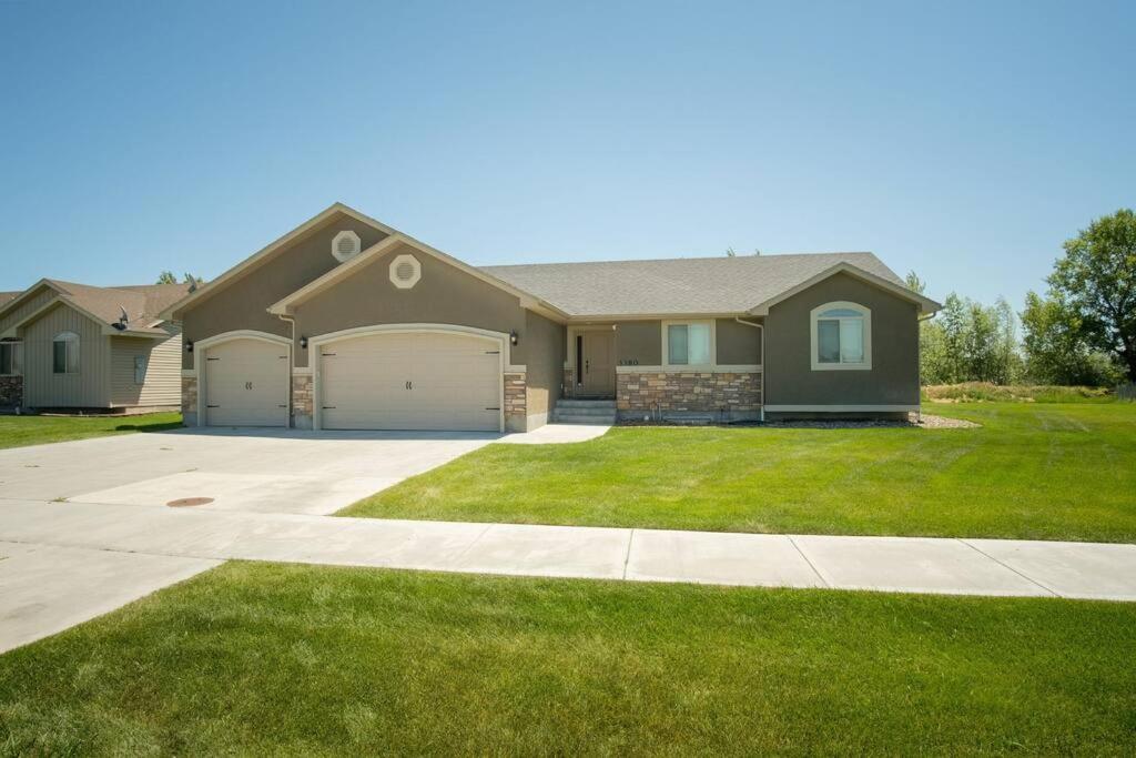 une maison avec une grande cour et une allée. dans l'établissement 3 Car Garage Full Kitchen Large Backyard Smart TVs, à Idaho Falls