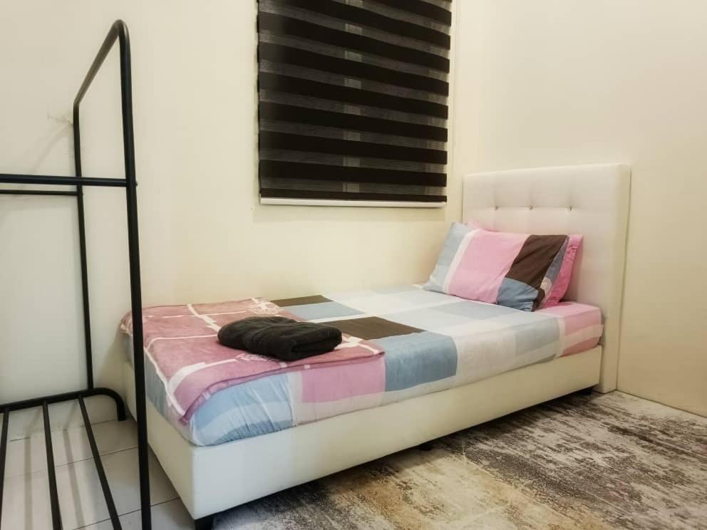 a small bed in a room with at Chek Embun Homestay in Padang Besar