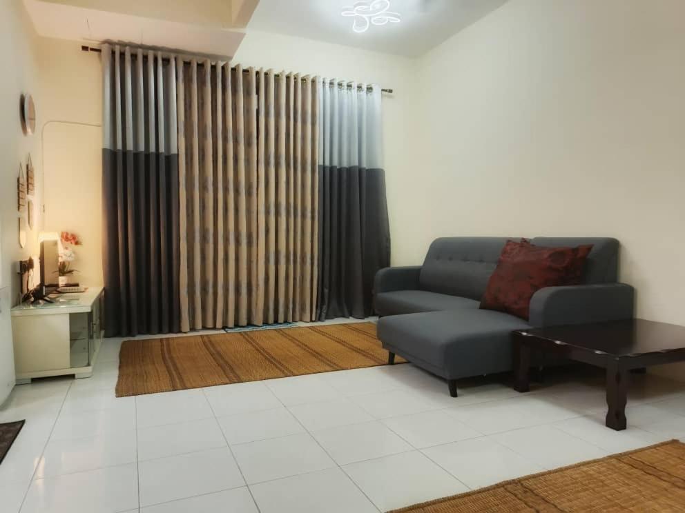 a living room with a couch and a table at Chek Embun Homestay in Padang Besar