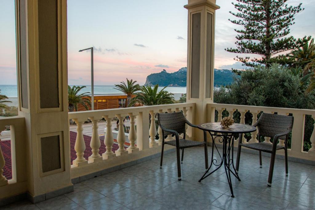 einen Balkon mit einem Tisch und Stühlen sowie Meerblick in der Unterkunft Hotel La Villa Del Mare in Cagliari