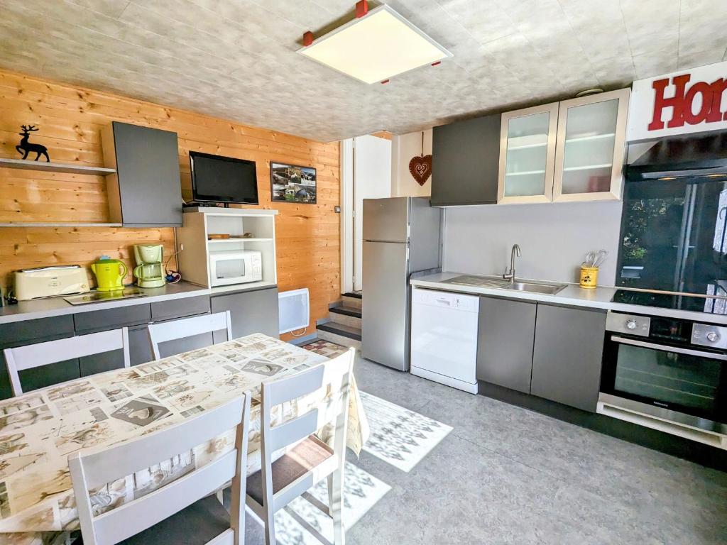 une cuisine avec une table et des chaises dans une pièce dans l'établissement Appartement cosy à La Bresse avec terrasse et parking, animaux admis - FR-1-589-689, à La Bresse