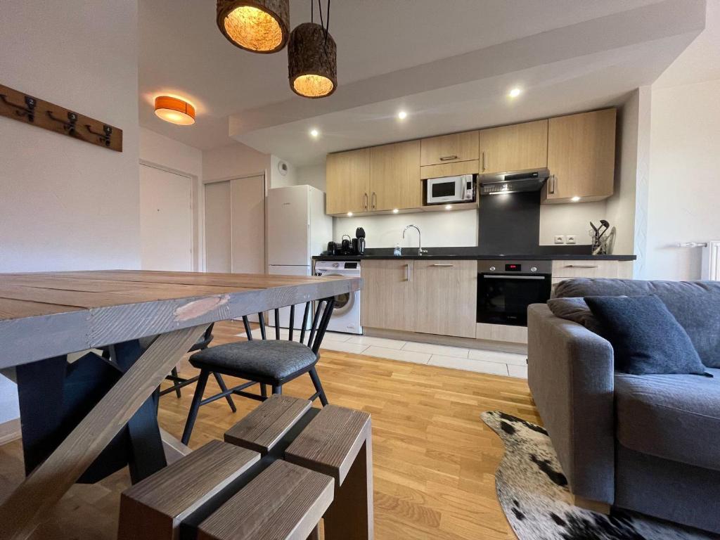 une cuisine et un salon avec une table et un canapé dans l'établissement Appartement lumineux avec balcons, WIFI et parking à Samoëns - FR-1-624-172, à Samoëns