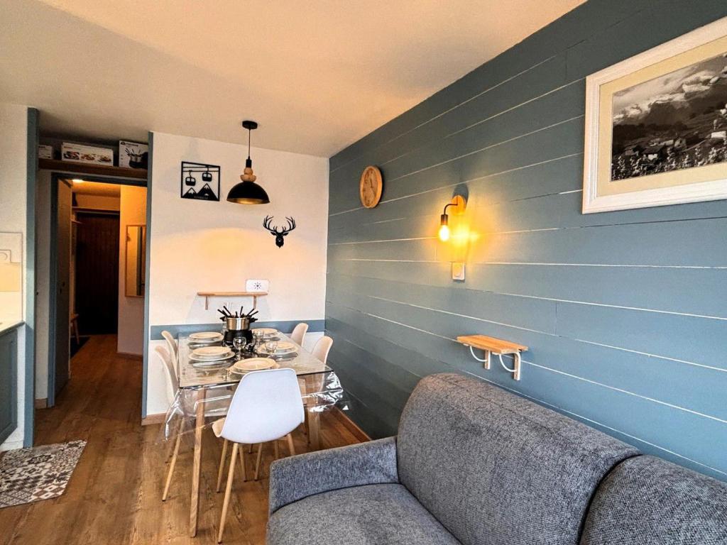 un salon avec une table et un mur bleu dans l'établissement Charmant 2 pièces pour 5 pers. avec cuisine équipée et wifi, au cœur d'Avoriaz - FR-1-634-104, à Morzine