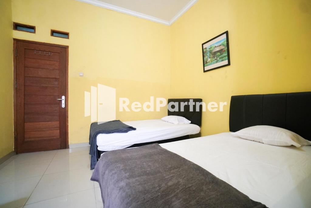 Postel nebo postele na pokoji v ubytování Surabaya Jaya Hotel near Soekarno Hatta Airport Redpartner