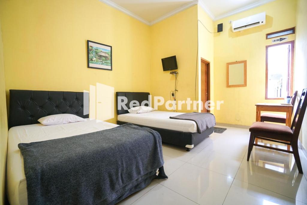 Postel nebo postele na pokoji v ubytování Surabaya Jaya Hotel near Soekarno Hatta Airport Redpartner