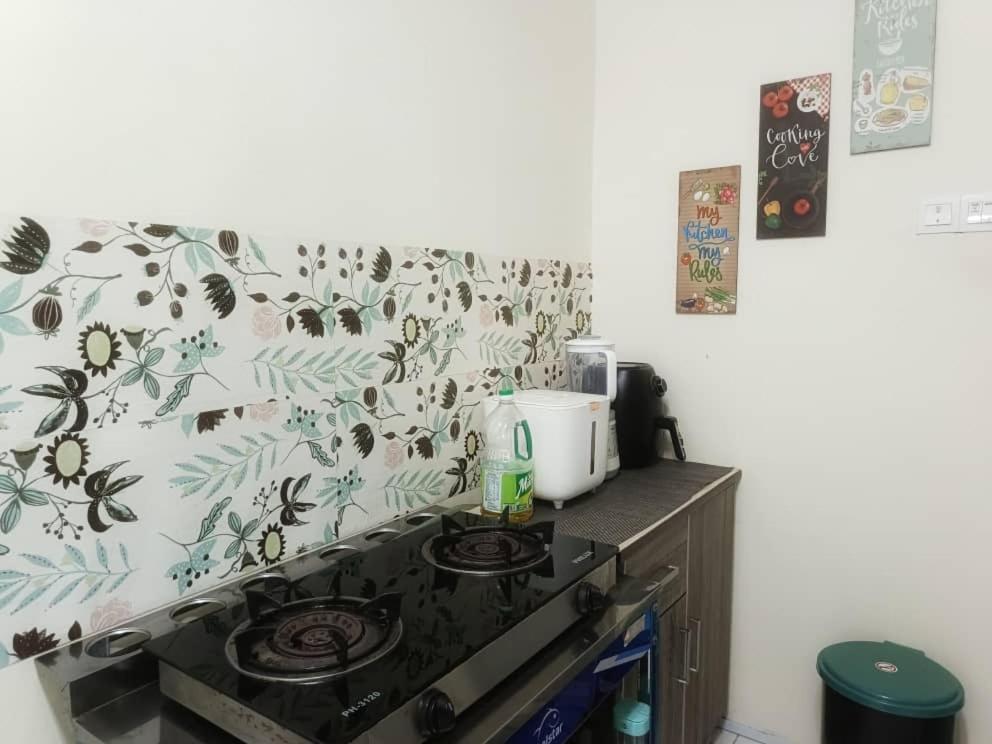 a kitchen with a stove with a floral wallpaper at Chek Embun Homestay in Padang Besar