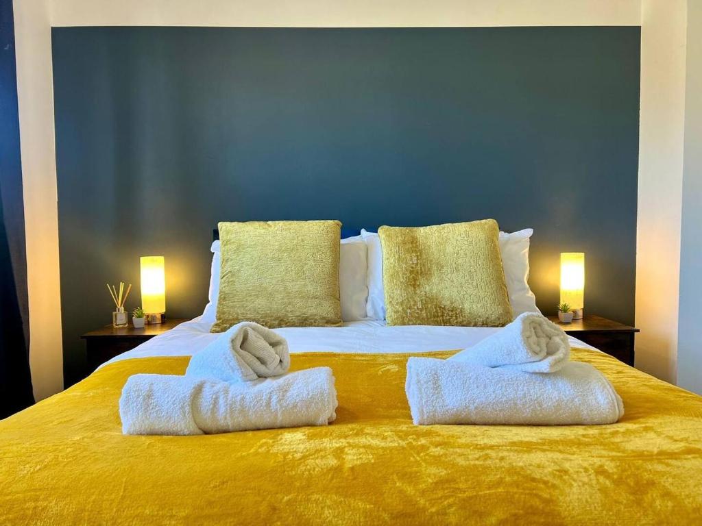 ein Schlafzimmer mit einem Bett mit Handtüchern darauf in der Unterkunft Long Stay 3br Parking Wifi in Corby