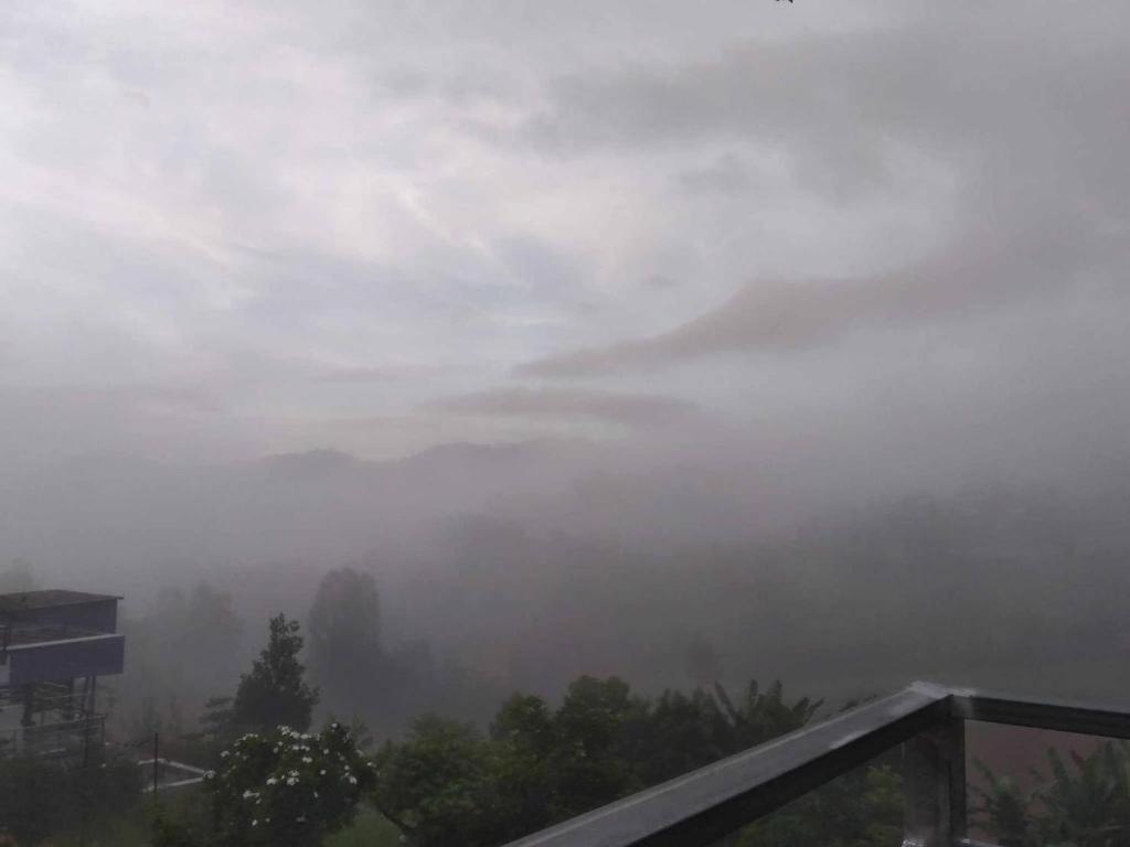 a foggy view of a mountain in the sky at สิรีรินทร์ ภูหมอก in Khao Kho