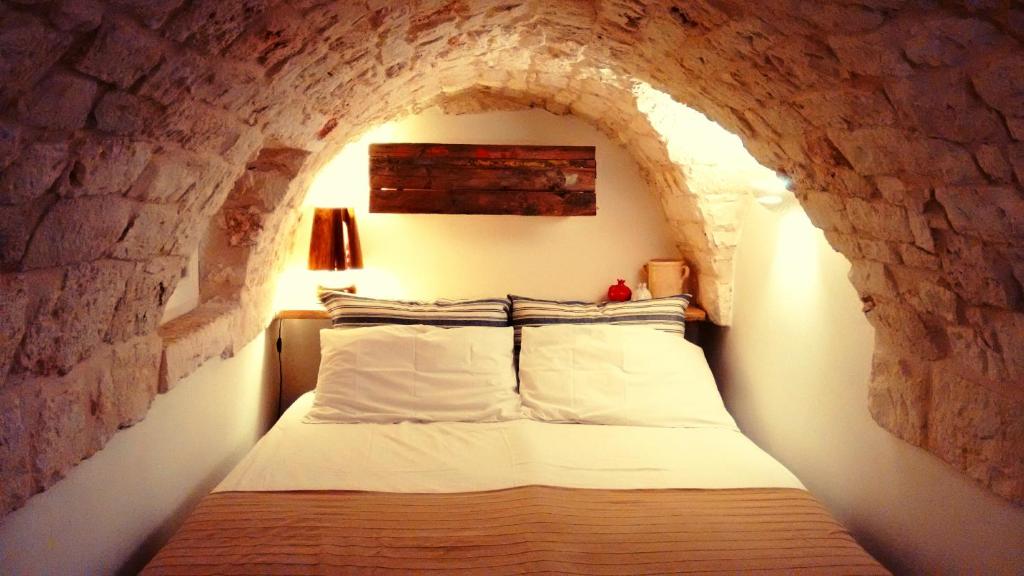 ein Schlafzimmer mit einem Bett in einer Steinmauer in der Unterkunft Chianca Bianca in Ostuni